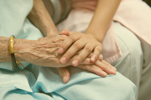 ældre kvinde og barn holder i hånd, nærhed, bedsteforældre, omsorg